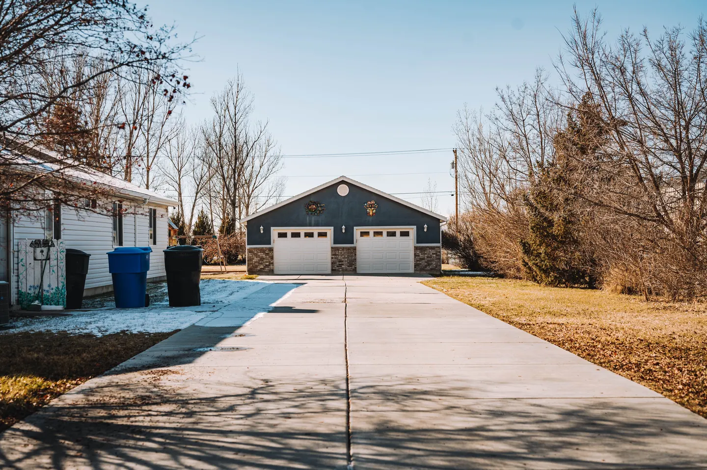 Residential concrete driveway with joints leading to detached garages