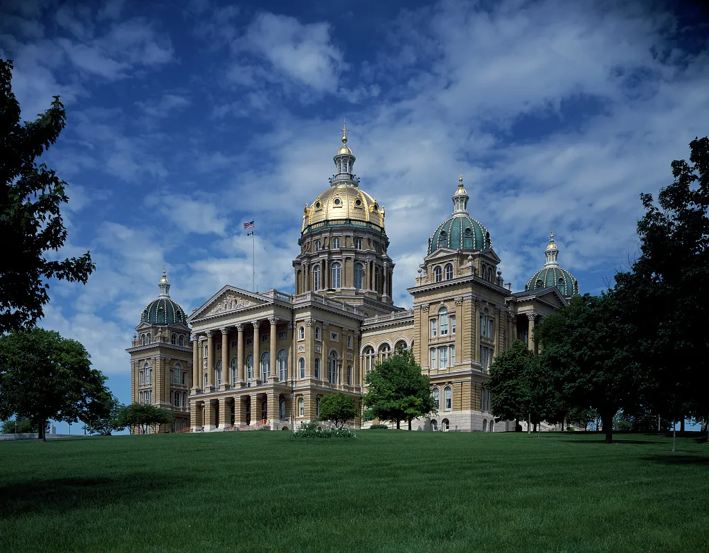 Iowa State Capitol in Des Moines surrounded by trees and lawn