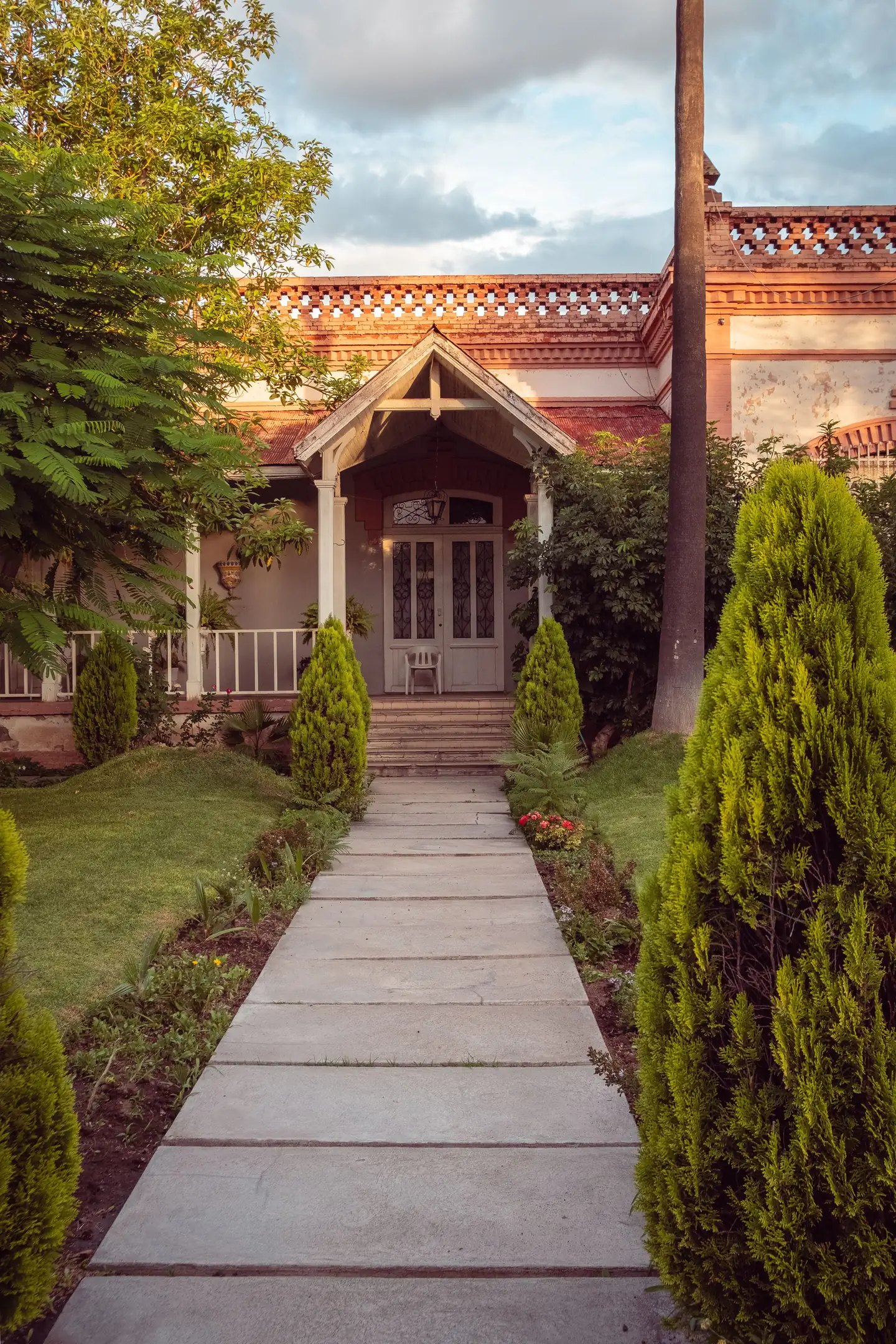 Jointed concrete walkway approaching a landscaped residential porch